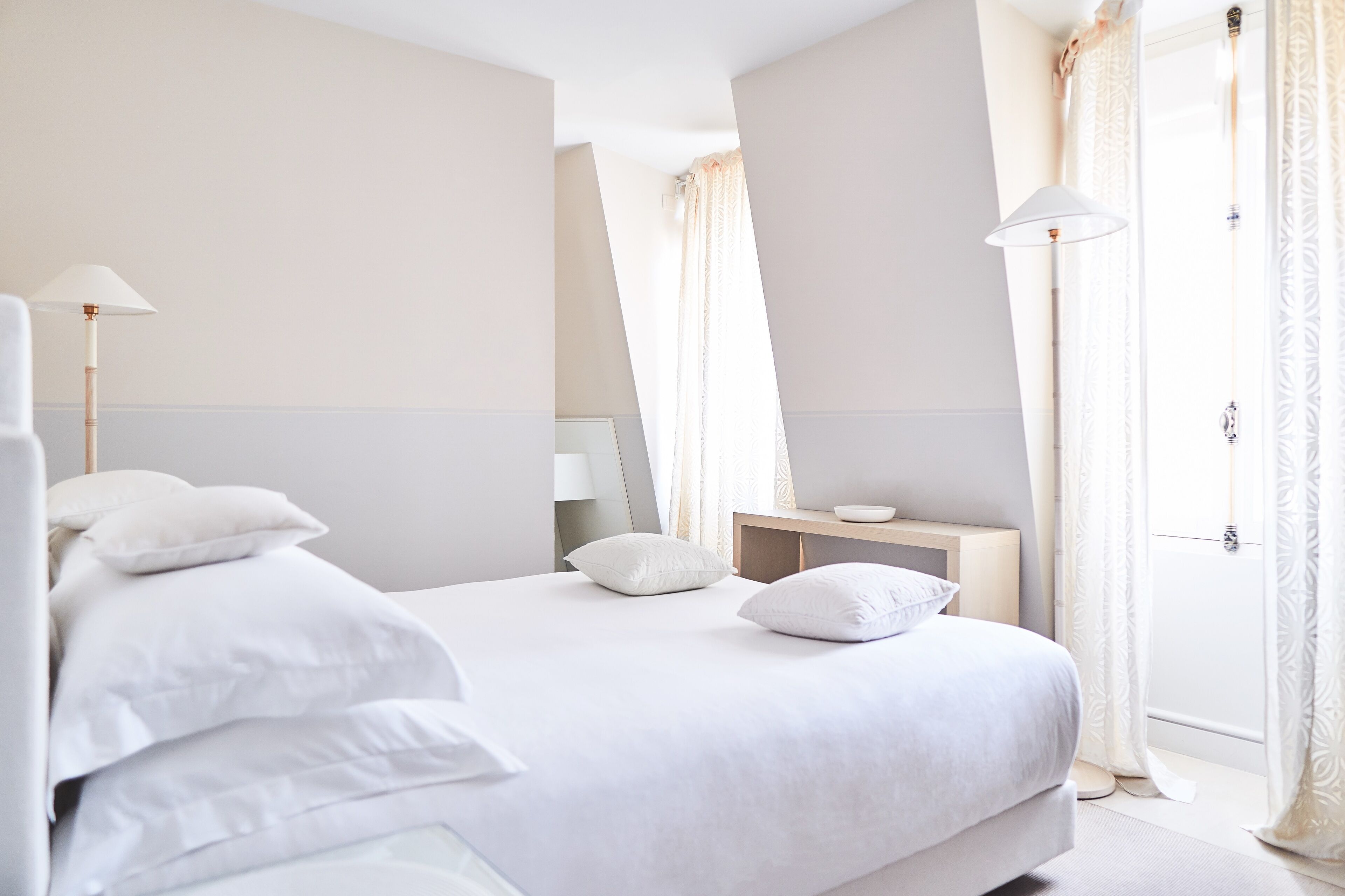 Een netjes ingerichte hotelkamer met een groot bed, twee nachtkastjes en een bijzettafel.
