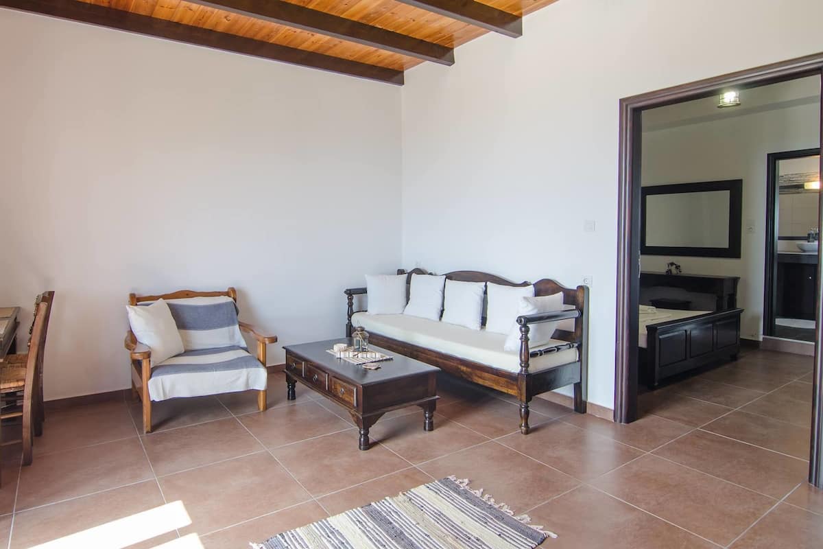 A living room with a sofa, armchairs, a coffee table, and a dining area with a table and chairs.