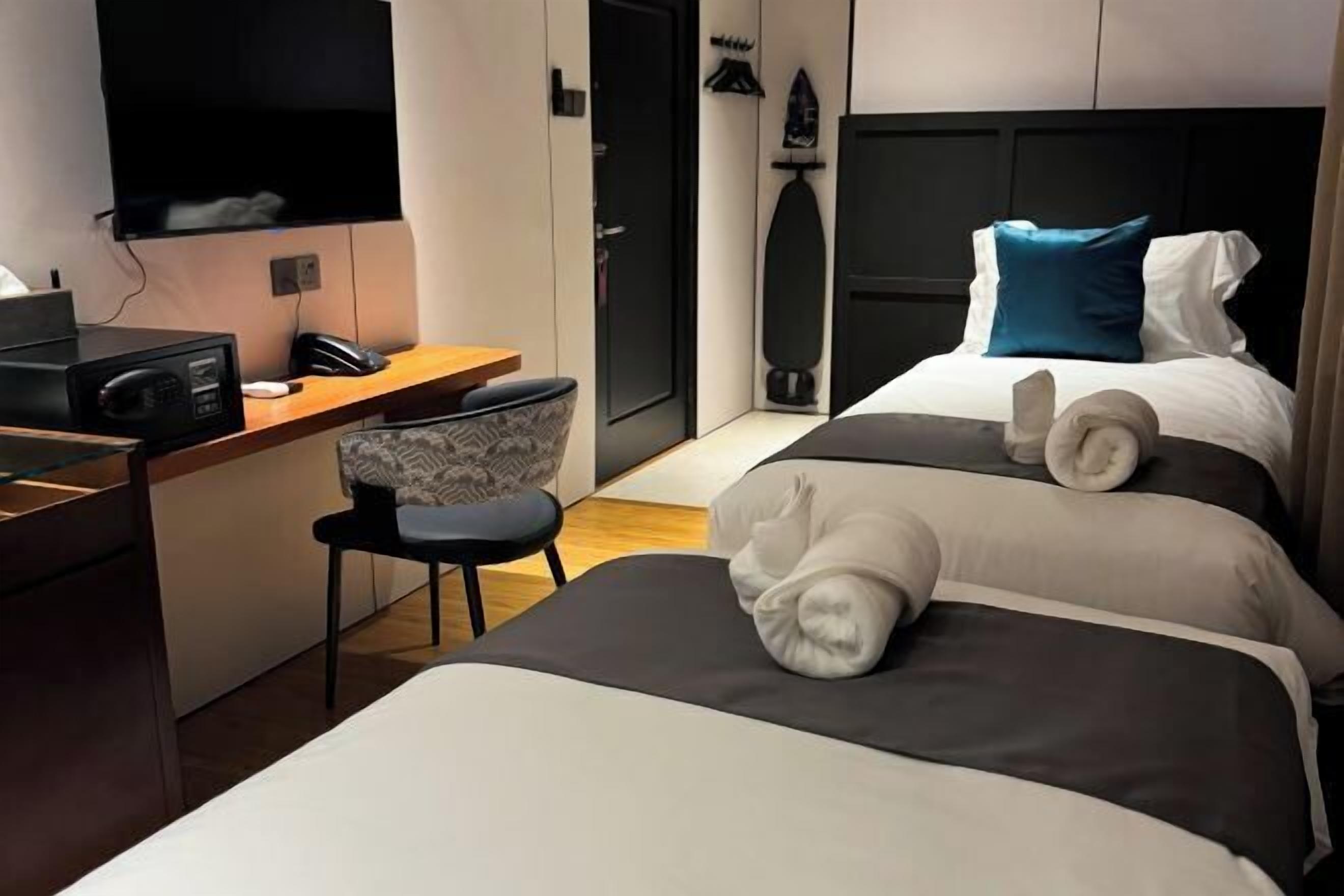 أغطية فراش متميزة وميني بار وخزنة داخل الغرفة ومكتب