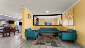 A living room with a sofa, chairs, a coffee table, and a dining area with a table and chairs. - Quality Inn & Suites Dublin (Dublin)