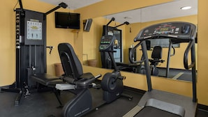A gym with exercise equipment, a TV, and a mirror. - Quality Inn & Suites Dublin (Dublin)