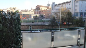 A view of a cityscape with buildings, a fenced area, and a tree. - Domus Vatican Holidays (Rome)