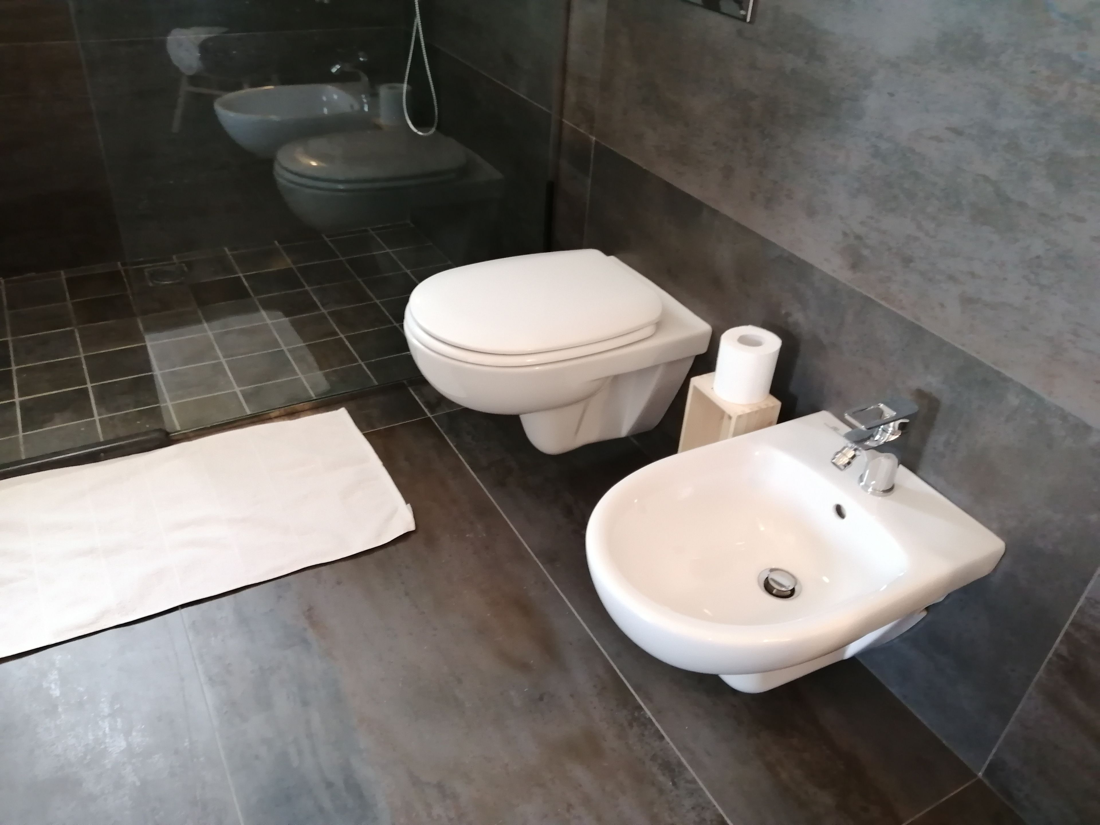 Un baño moderno con inodoro, bidé y lavamanos.