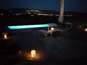 Una piscina al aire libre, sillones reclinables de piscina