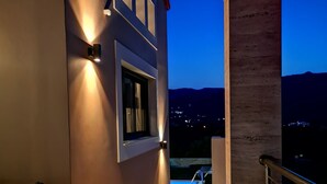 A balcony with a view of a pool and mountains at dusk. - Marina's Villas (Malevizi)