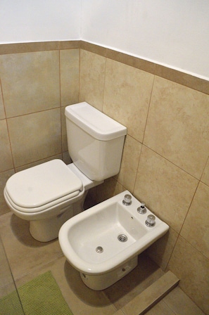 Une salle de bain avec des toilettes et un bidet.