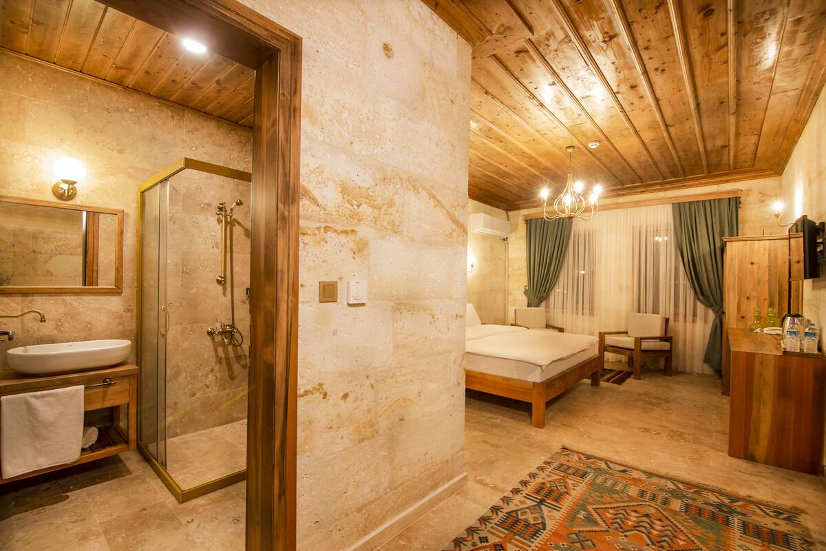 A bedroom with a bed, bedside table, and a mirror.