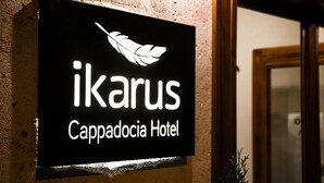 A sign for Ikarus Cappadocia Hotel with a feather logo. - Ikarus Cappadocia Hotel (Nevsehir)