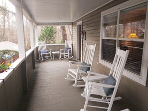 Relax on the covered porch with comfortable rocking chairs and a small table.