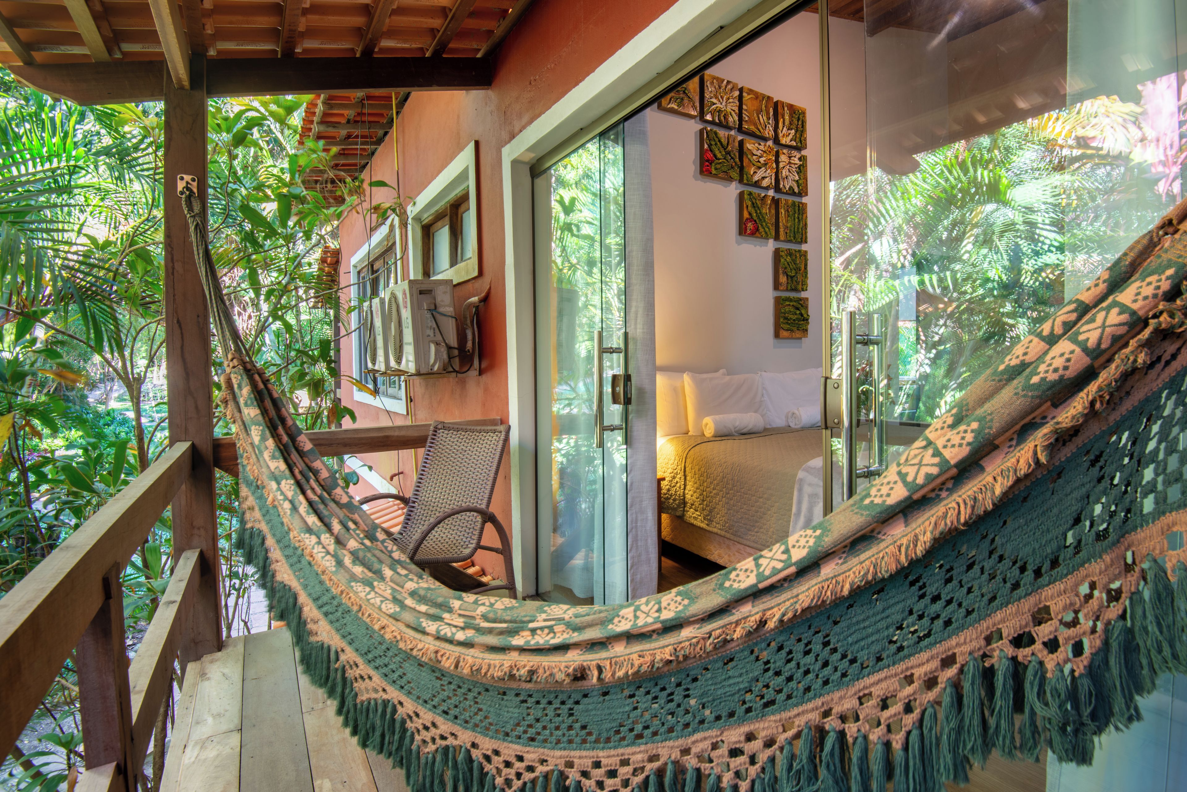 Una hamaca en un balcón con vistas a un dormitorio y un baño.