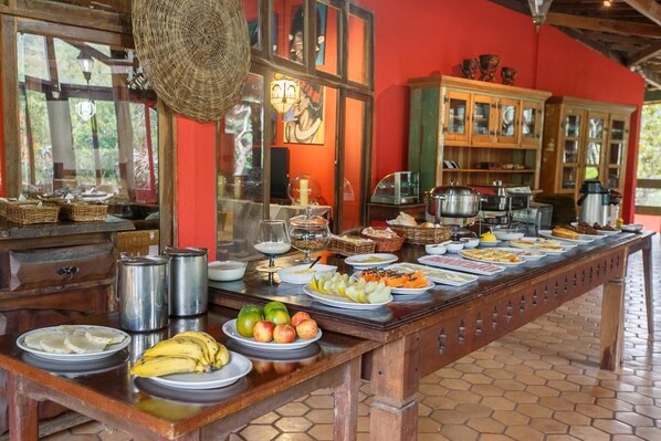 A buffet setup with various food items and kitchenware. - Pousada Lendas do Capão (Palmeiras)