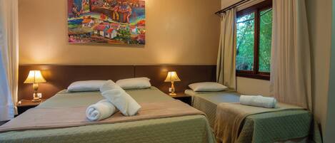 A hotel room with two beds, a painting on the wall, and a window with curtains.