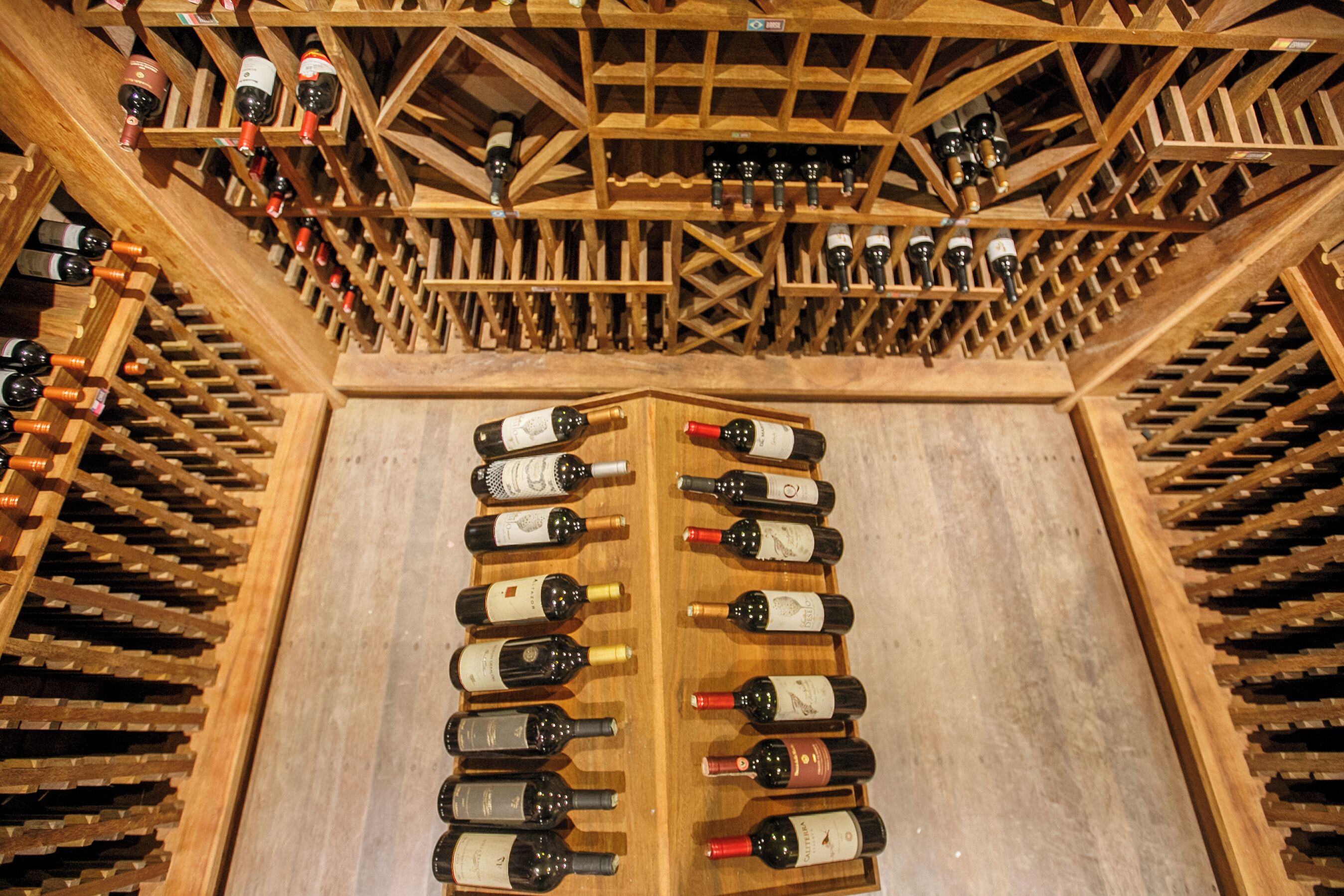Una bodega con estanterías de madera llenas de numerosas botellas.