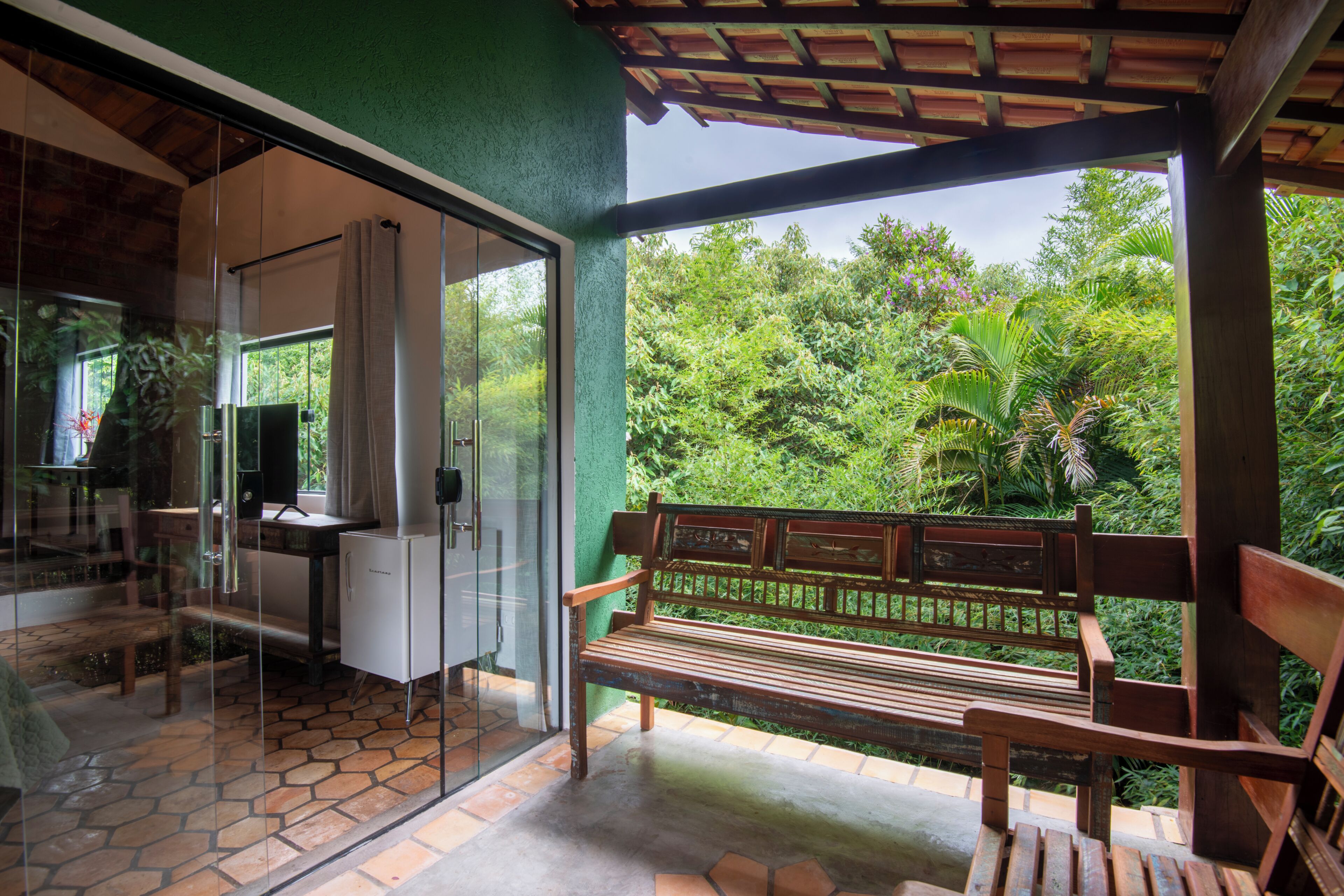 A wooden bench with a view of lush greenery.