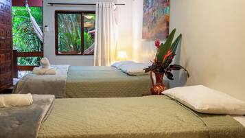 A hotel room with two beds, a window with curtains, a painting on the wall, and a potted plant.