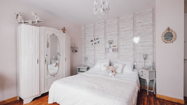 A bedroom with a large bed, a wardrobe, a dresser, a nightstand, and a chandelier. - Les iris Chambres D Hôtes (Niedermorschwihr)