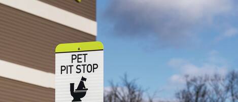 A sign for a pet pit stop with a Home Depot store in the background.