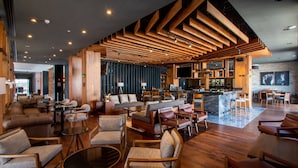 A modern interior with wooden beams, seating areas, and a bar. - DoubleTree by Hilton Celaya (Celaya)