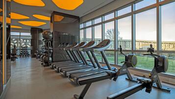 A gym with treadmills, weights, and exercise equipment.