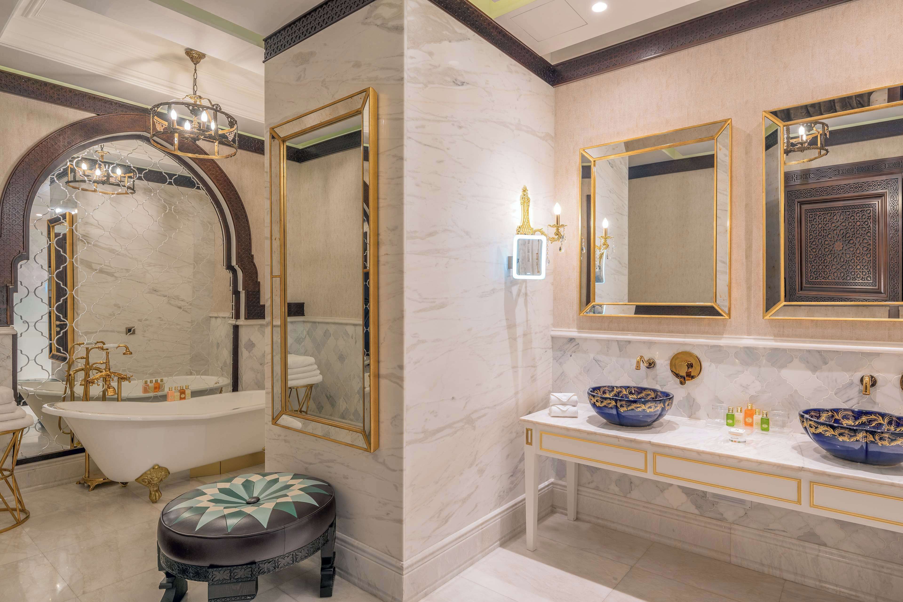 A luxurious bathroom with a freestanding bathtub, a large mirror, and a vanity with two sinks.