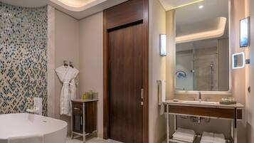 A modern bathroom with a freestanding bathtub, a vanity with a mirror, and a shower area.