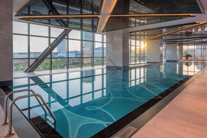 Una piscina techada, sillones reclinables de piscina