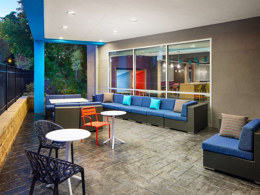 An outdoor patio area with a seating arrangement including a sofa, chairs, and a table.