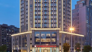 Un edificio de Hilton Garden Inn de varios pisos con un letrero llamativo en la parte superior.