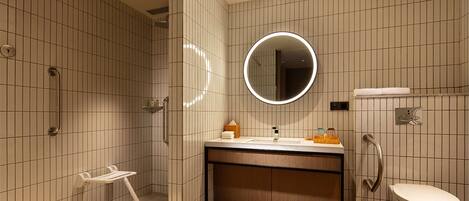 A modern bathroom with a shower, toilet, and sink.