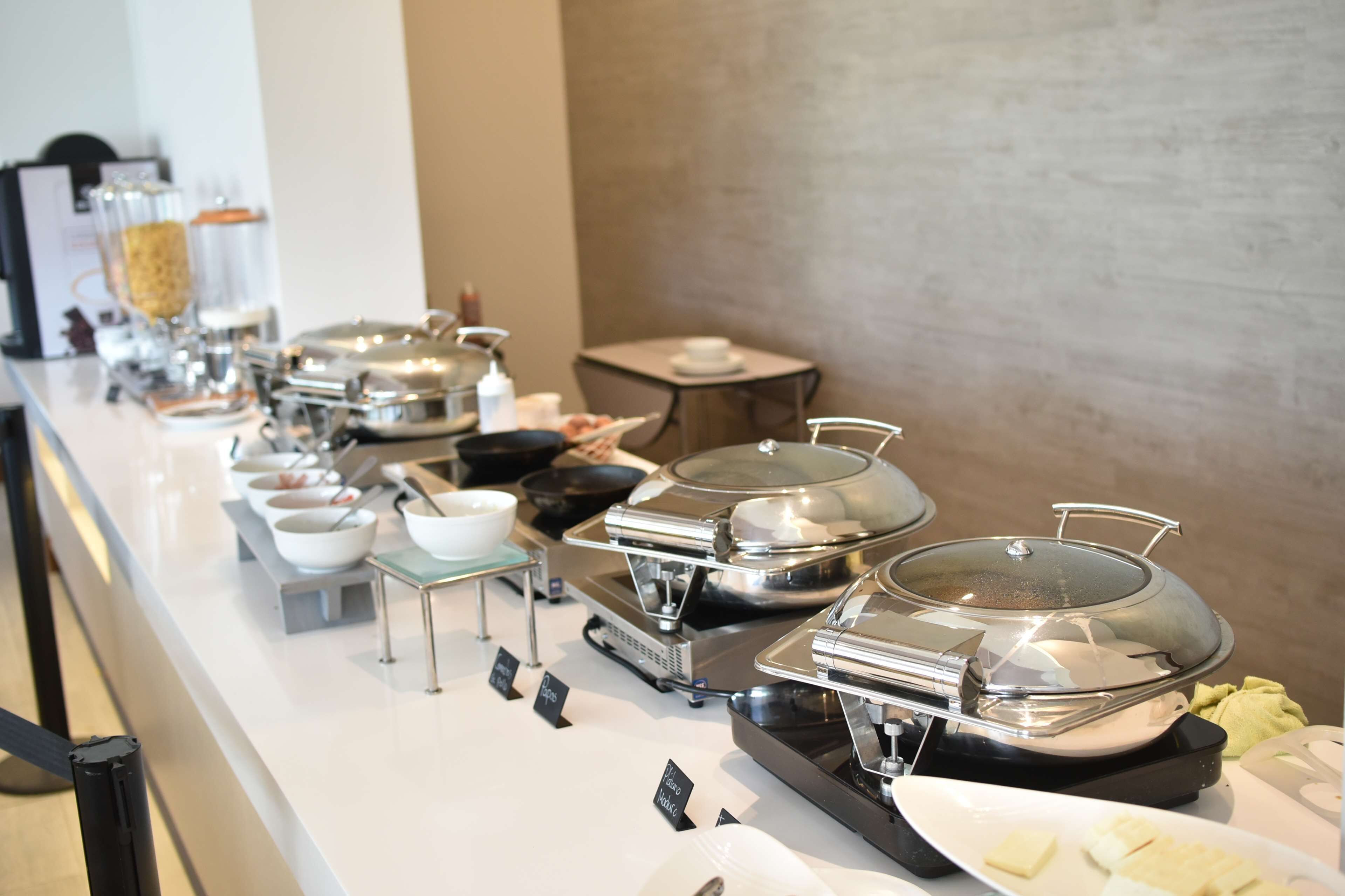 A buffet setup with various food stations, including hot and cold options, and a coffee station.