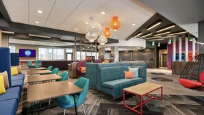 A modern lounge area with seating, tables, and a television screen displaying 'TRU by Tiffin'.