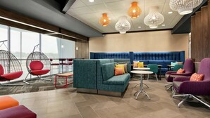 A modern lounge area with seating, tables, and hanging chairs.
