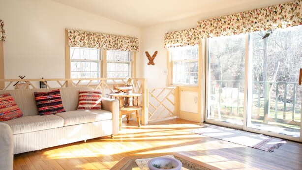 A cozy living room with a sofa, a coffee table, and a window with a view of the outdoors. - The Anderson Cottage Bed & Breakfast (Warm Springs)