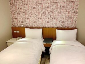A hotel room with two beds, a wooden headboard, a patterned tapestry, a bedside table with a lamp, and a phone. - Teeya Apartment (Taipei)