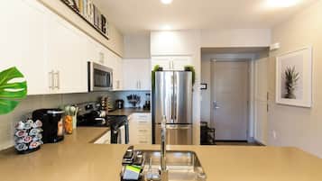 Bright full kitchen with stainless appliances and an island sink