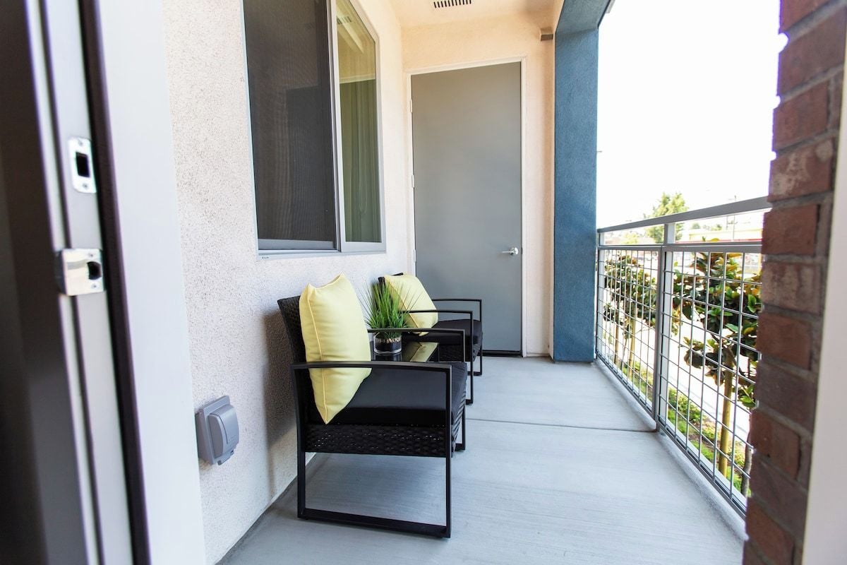 Private balcony with cozy seating and a leafy view, a relaxing spot