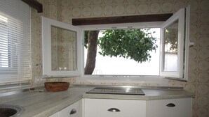 Een keuken met een raam, een spoelbak en een aanrecht.
