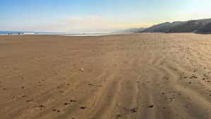 A wide sandy beach with footprints, a clear sky, and distant mountains. - The Bay - The Bolthole (Filey, near Scarborough)
