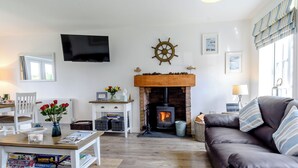 A cozy living room with a fireplace, a television, and a comfortable seating area. - The Bay - The Bolthole (Filey, near Scarborough)
