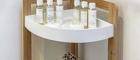 A shelf with various toiletries and a vase with flowers.