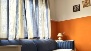 A room with a bed, a nightstand, a lamp, and a window with curtains. - M221 - Marcelli, new two-room apartment 100mt from the sea (Marcelli)