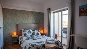 A bedroom with a bed, bedside lamps, a chair, and a view of the outside. - Just4uApartment 2 - Near Lisbon & Beach - With AC (Almada)