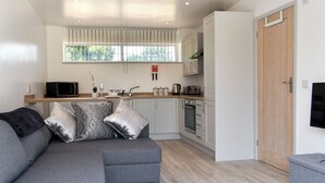 A modern kitchen with white cabinets, a microwave, and a toaster.