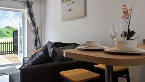 A dining area with a table, chairs, a sofa, and a window with a view.
