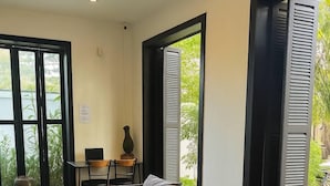 Un área de estar moderna con suelo a cuadros blancos y negros, un sofá y una mesa con sillas.