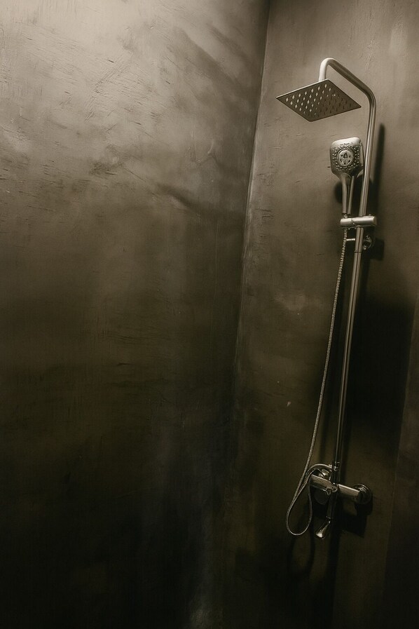 A shower with a handheld showerhead and a fixed showerhead.