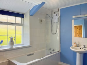 Un bagno con vasca, doccia e lavandino.