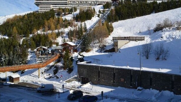 A modern building with multiple floors, surrounded by snow-covered terrain and trees. - Studio for 2 at slopes, pets allowed (Les Menuires)