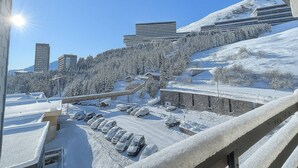 A snowy landscape with modern buildings, a parking area, and a clear blue sky. - Studio for 2 at slopes, pets allowed (Les Menuires)