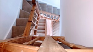 Una escalera de madera con barandilla que lleva a un rellano.